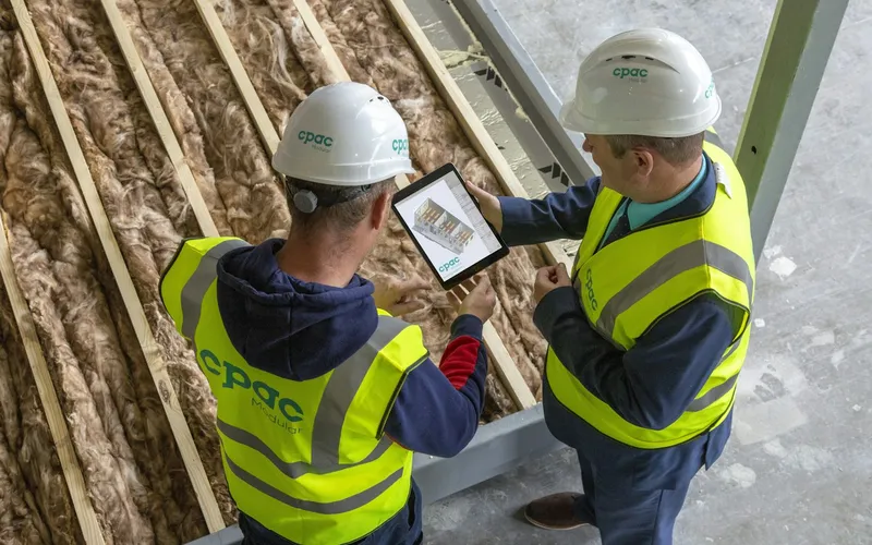 Técnicos avaliando uma obra com tablet