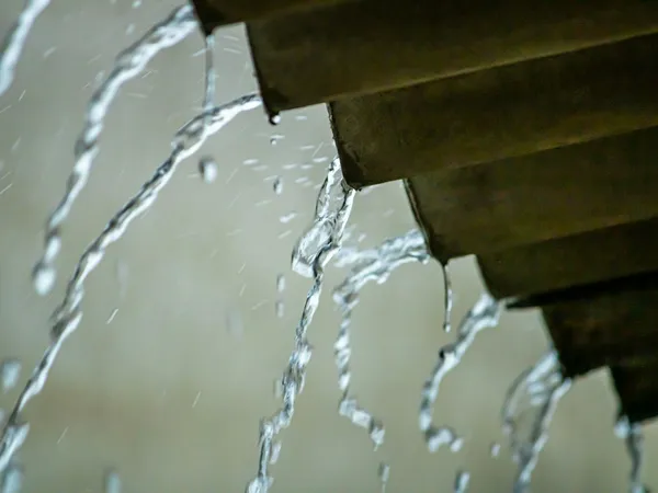 Água da chuva escorrendo sobre telhas