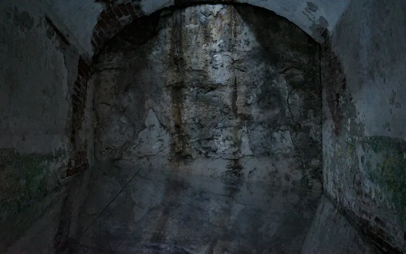 Parede de concreto escura e úmida em um ambiente subterrâneo