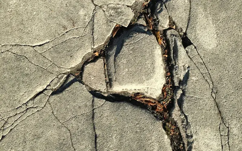 Superfície de concreto com trincas e pedaços soltos