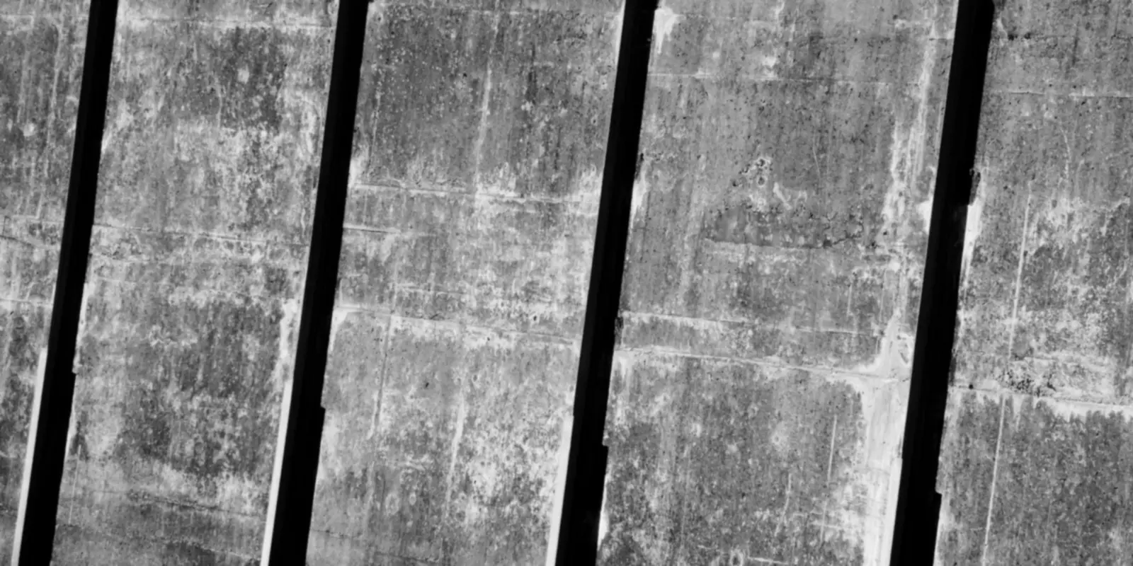 Paredes de concreto com marcas de umidade e manchas claras