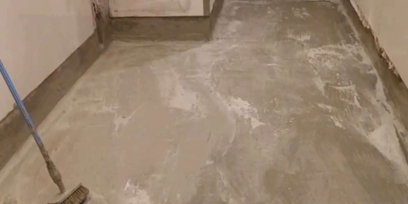 Rolo aplicando a impermeabilização em demãos no piso de área molhada